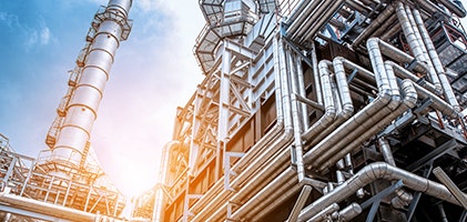 Oil refinery plant in front of a sunset