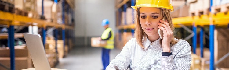A female associate in a hard hat and business casual on the phone