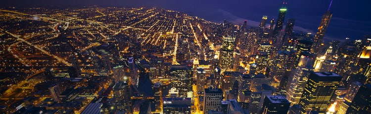 A landscape of city lights at nighttime lighting up the night sky