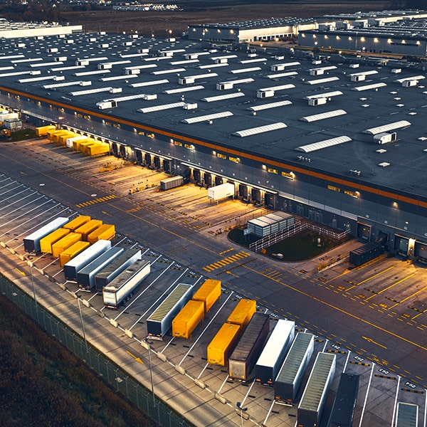 Distribution center parking lot filled with shipping bins and 18-wheel trucks